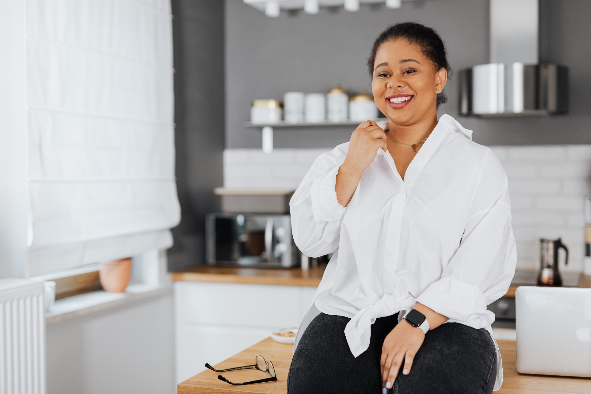 Smiling Black woman in a bright kitchen — hormone health and nutrition for Black women