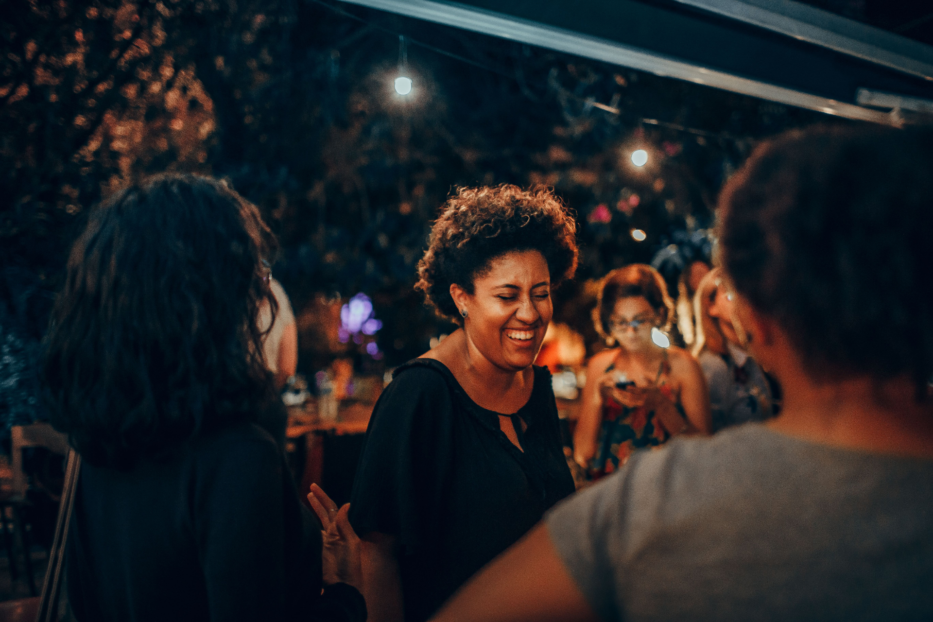 Black women laughing together at an outdoor gathering