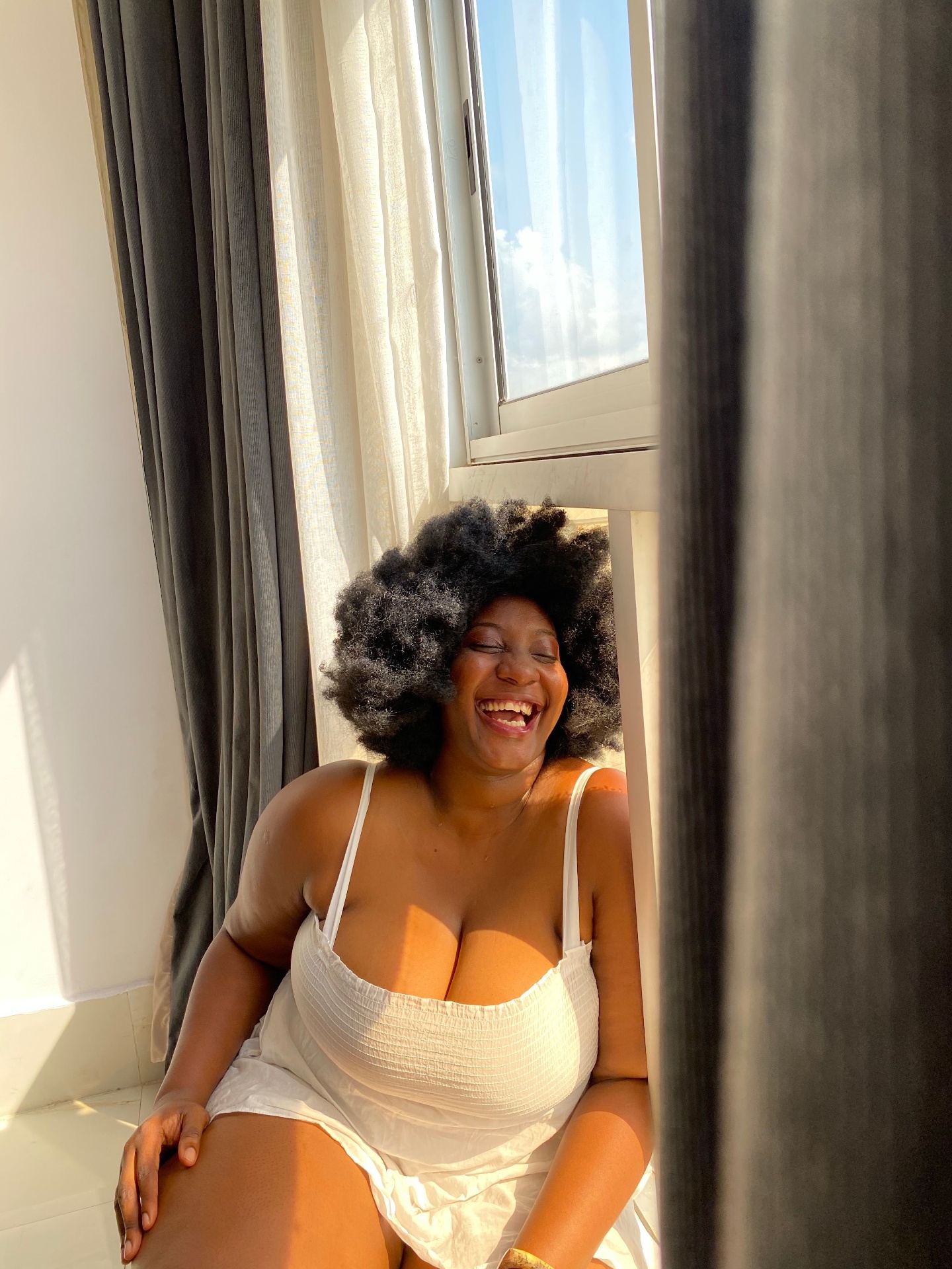 Black woman laughing joyfully in sunlight